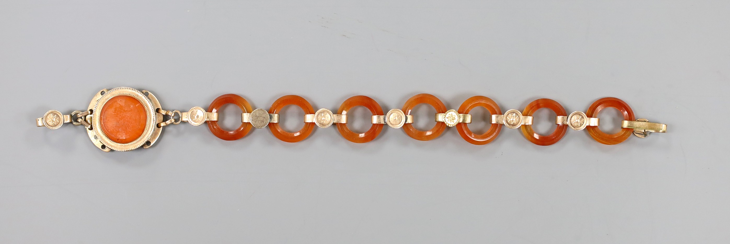 Part of an early 20th century yellow metal and carnelian disc link set bracelet, 14.6cm, gross weight 7.3 grams.
